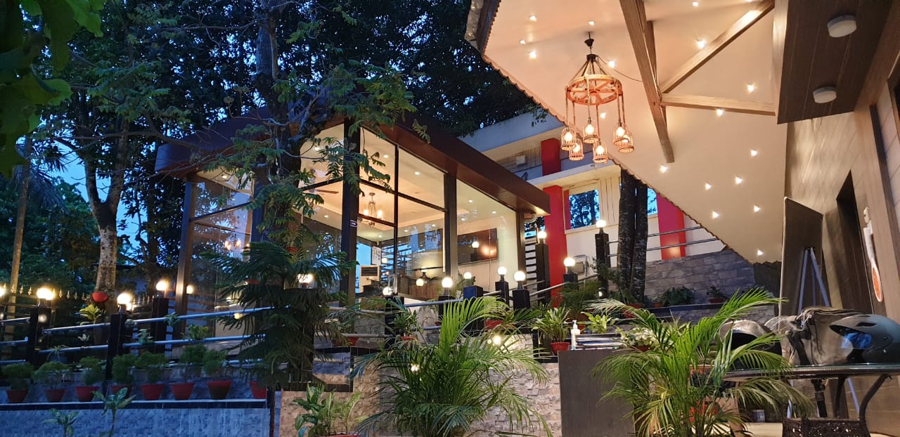 The glass-fronted entrance to JBS, lit warmly at dusk