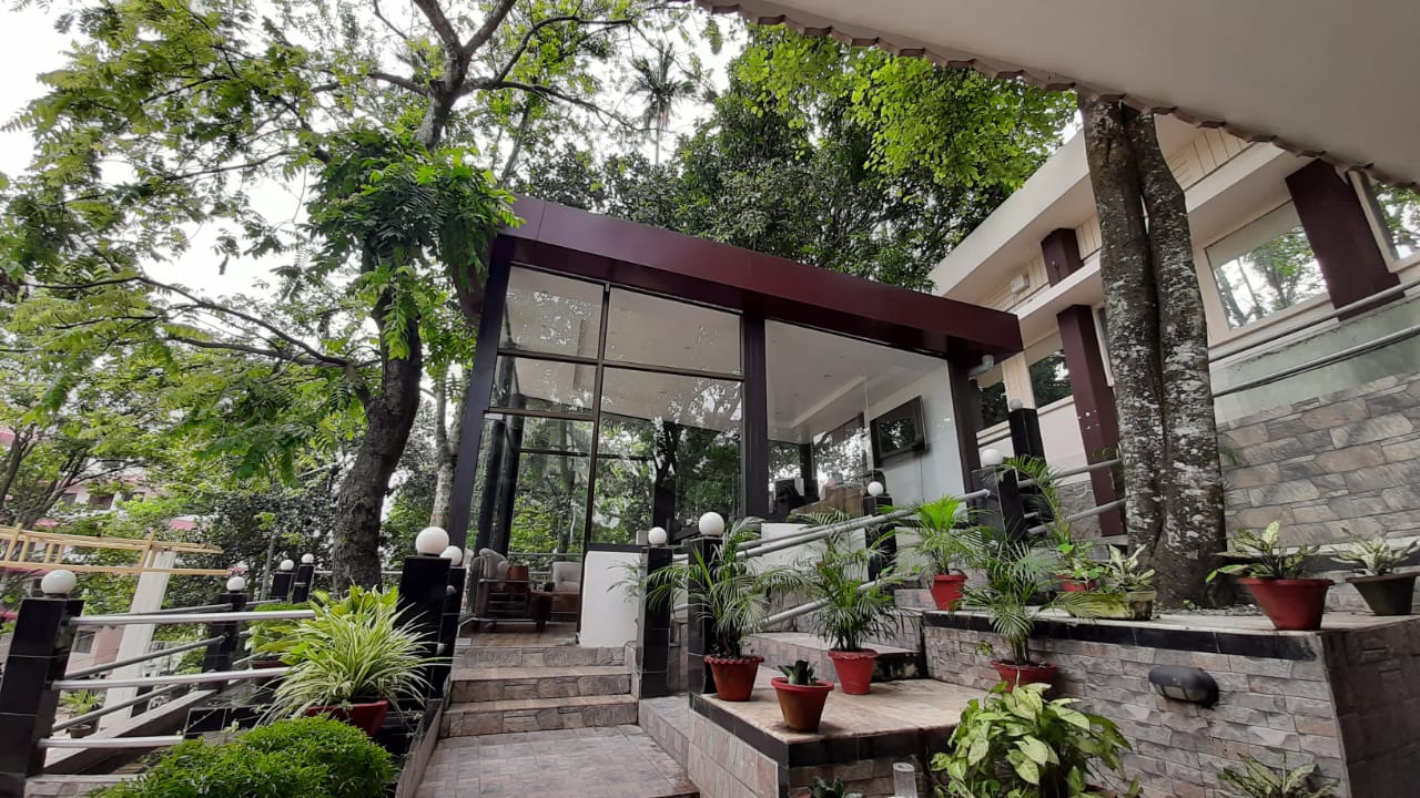 Glass-fronted foyer set among mature trees on the hillside